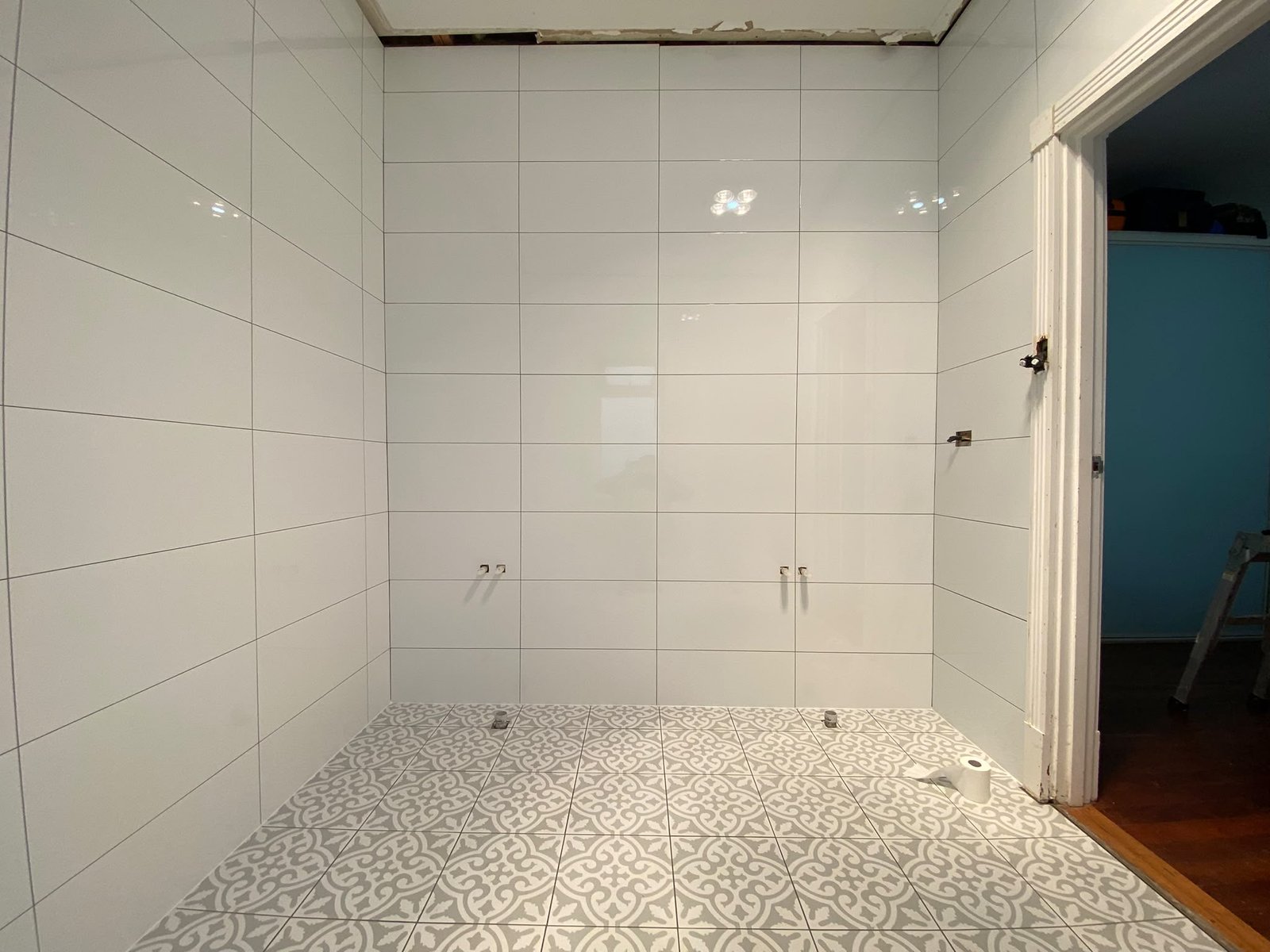 White gloss wall tiles with patterned feature floor in a Perth laundry