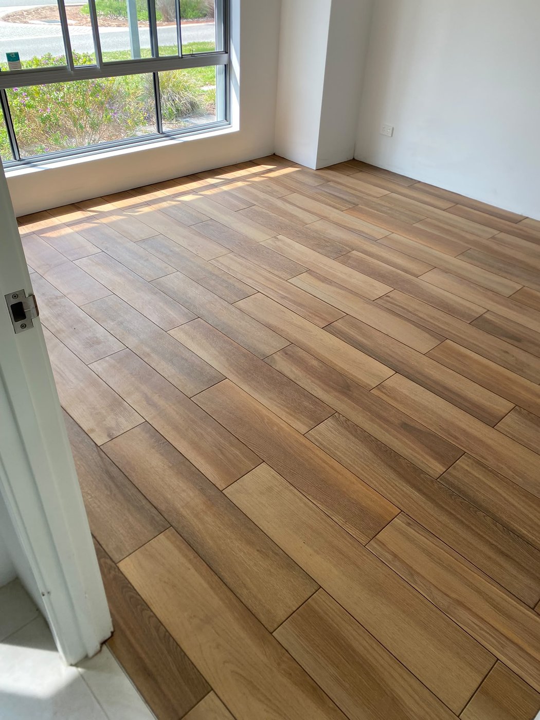Timber-look porcelain plank flooring in a bright Perth living space